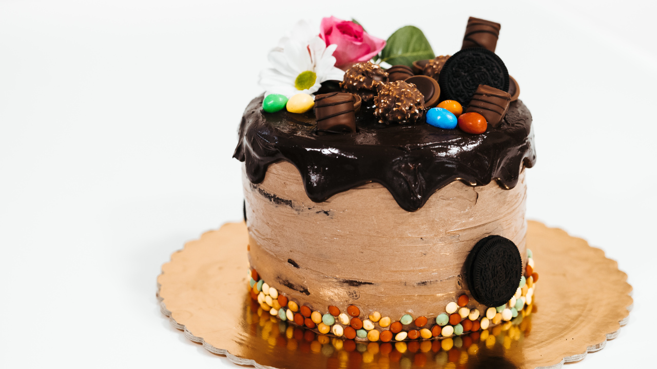 Торт с кремом и шоколадом украшен сладостями