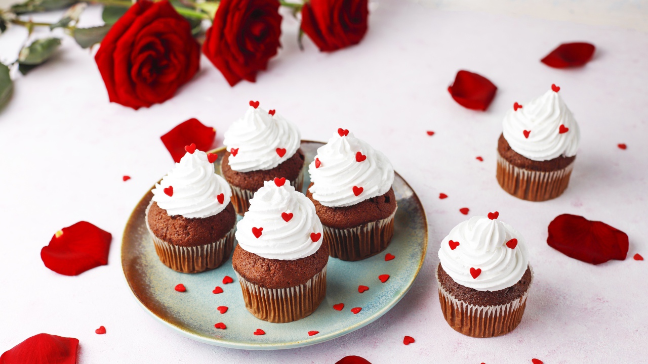 Кексы с кремом на столе с букетом роз 