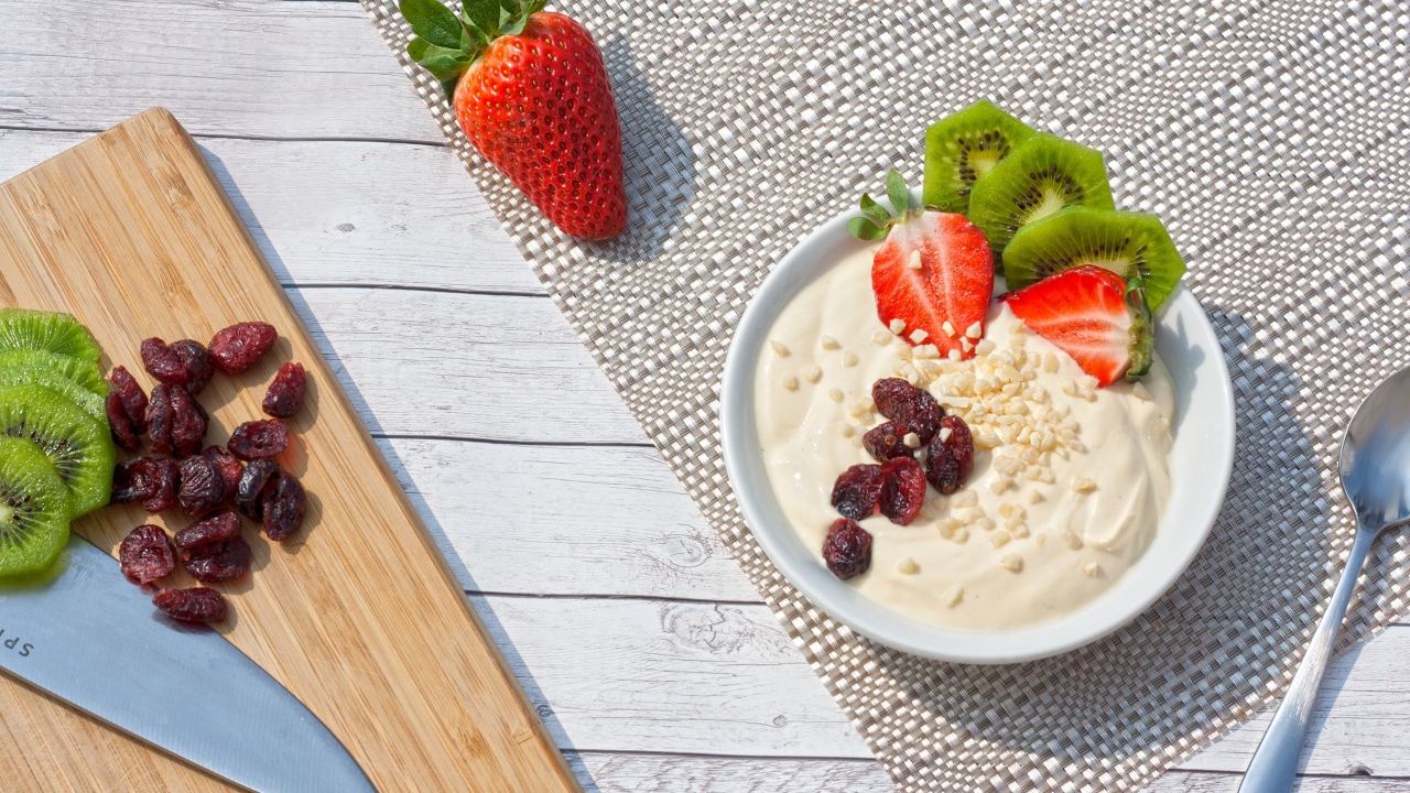 Десерт на столе с клубникой, киви и сушеной вишней