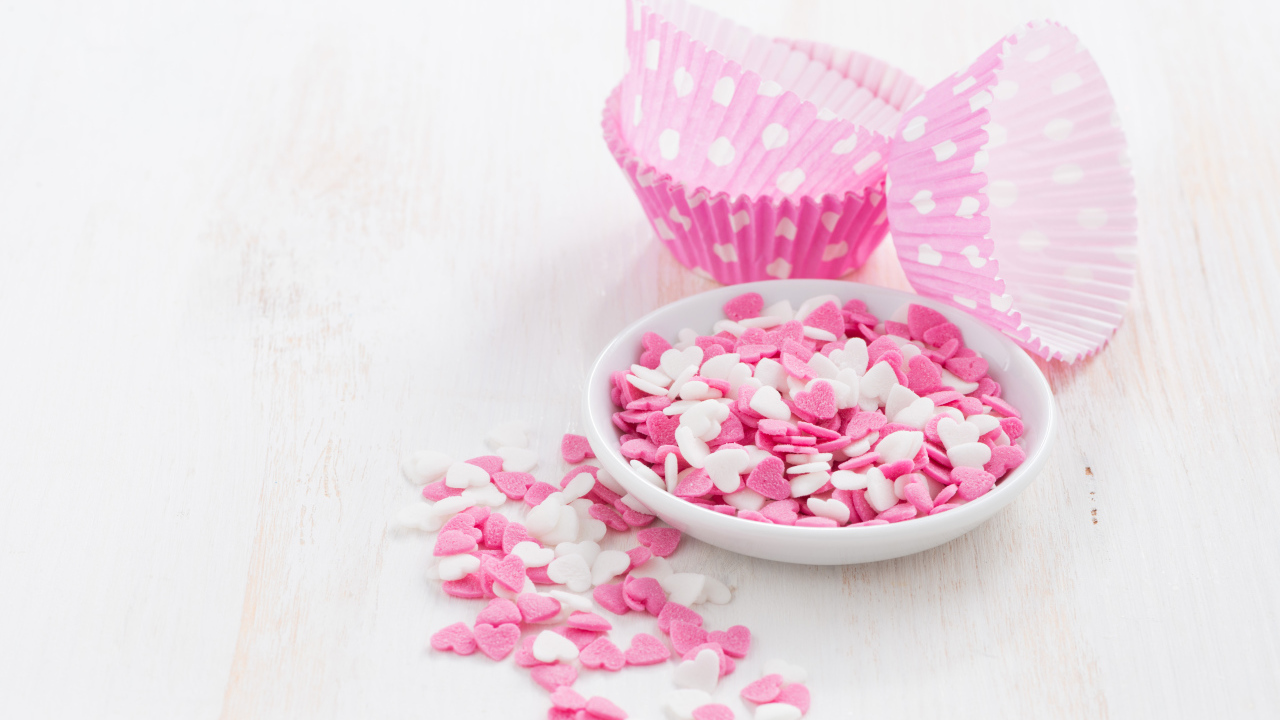 Маленькие белые и розовые сердечки на столе 