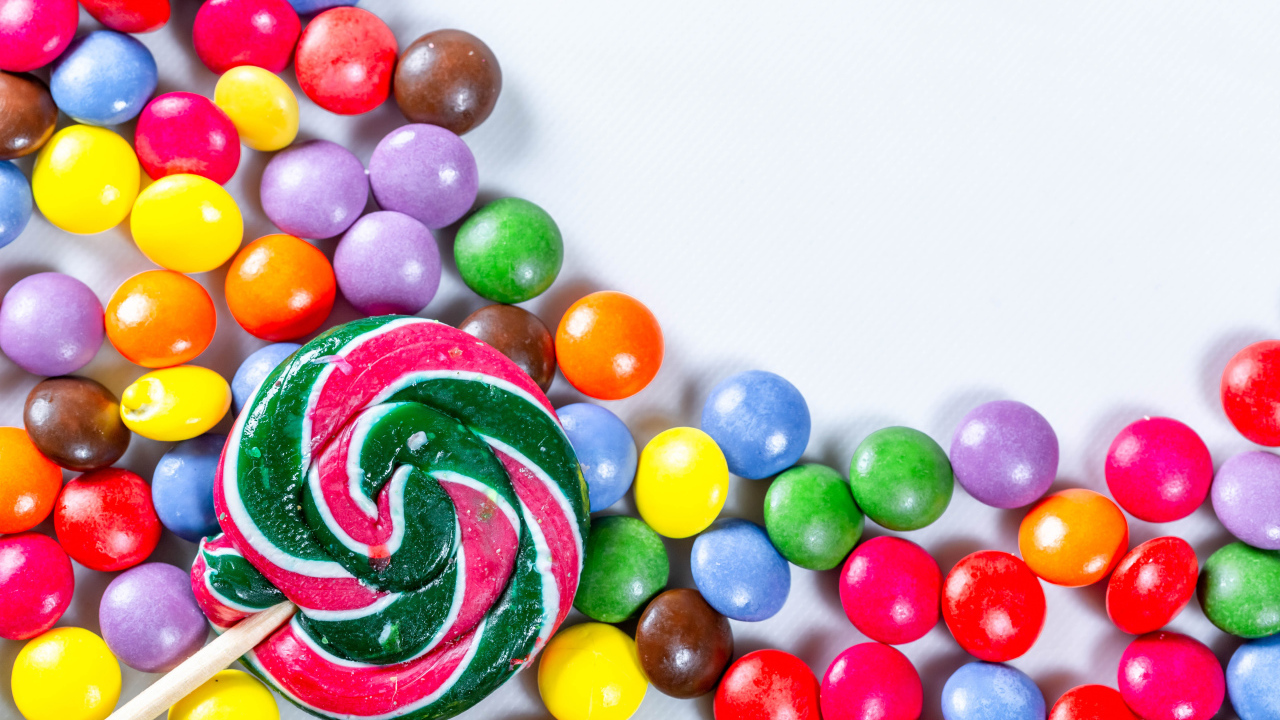 Разноцветные конфеты в глазури и карамель на белом фоне 