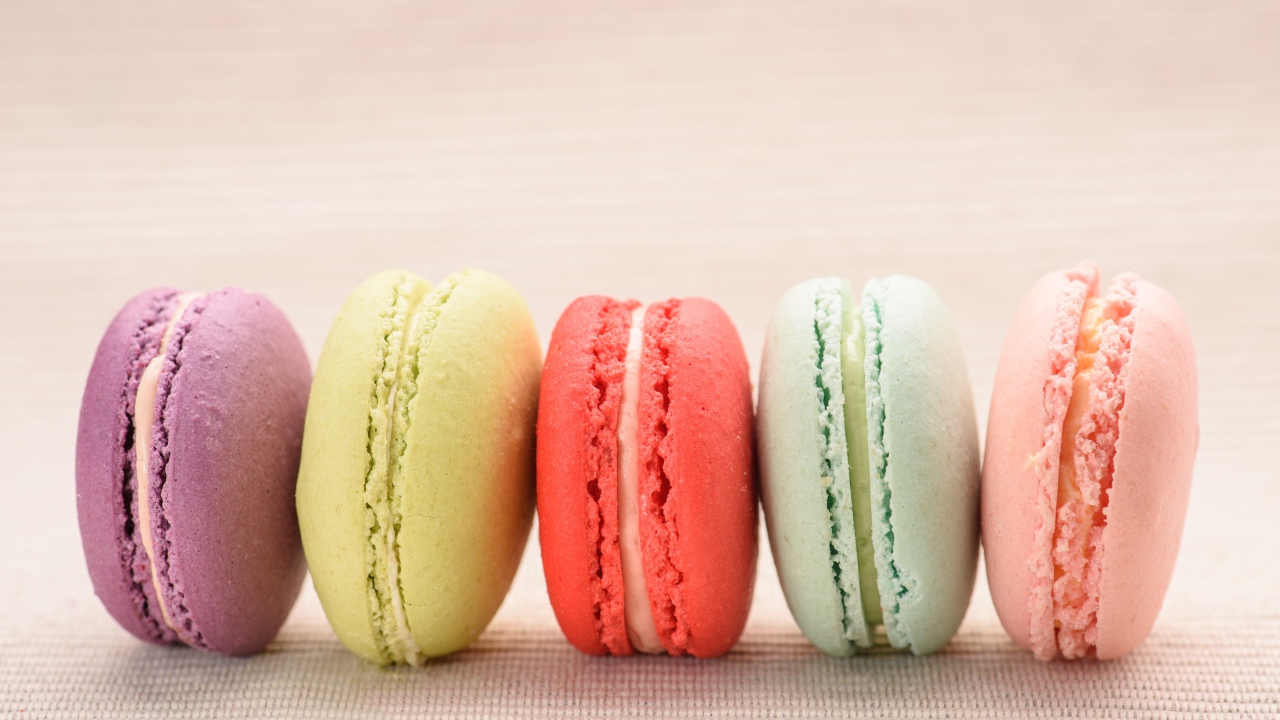 Разноцветное печенье макарон на розовом фоне 