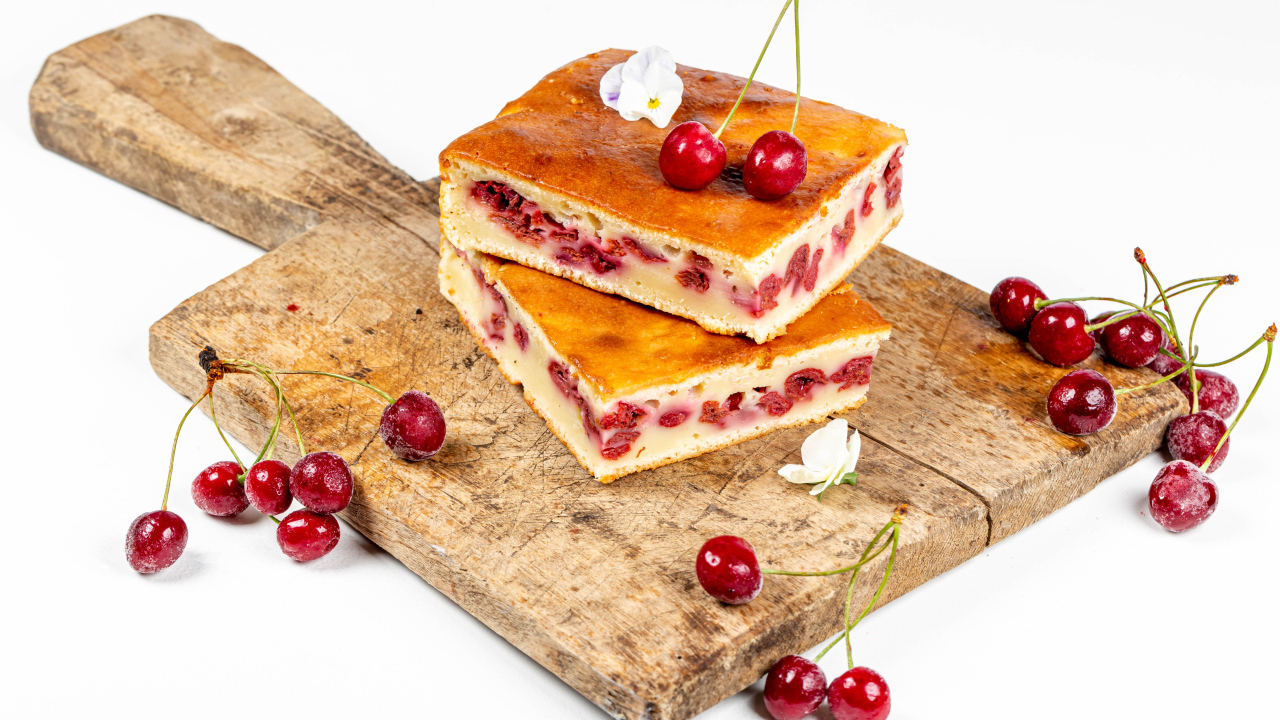 Пирог с вишнями на доске на белом фоне