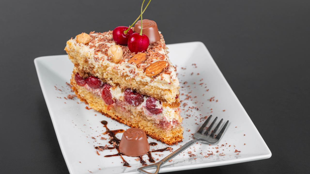 Кусок торта с ягодами вишни и миндальным орехом