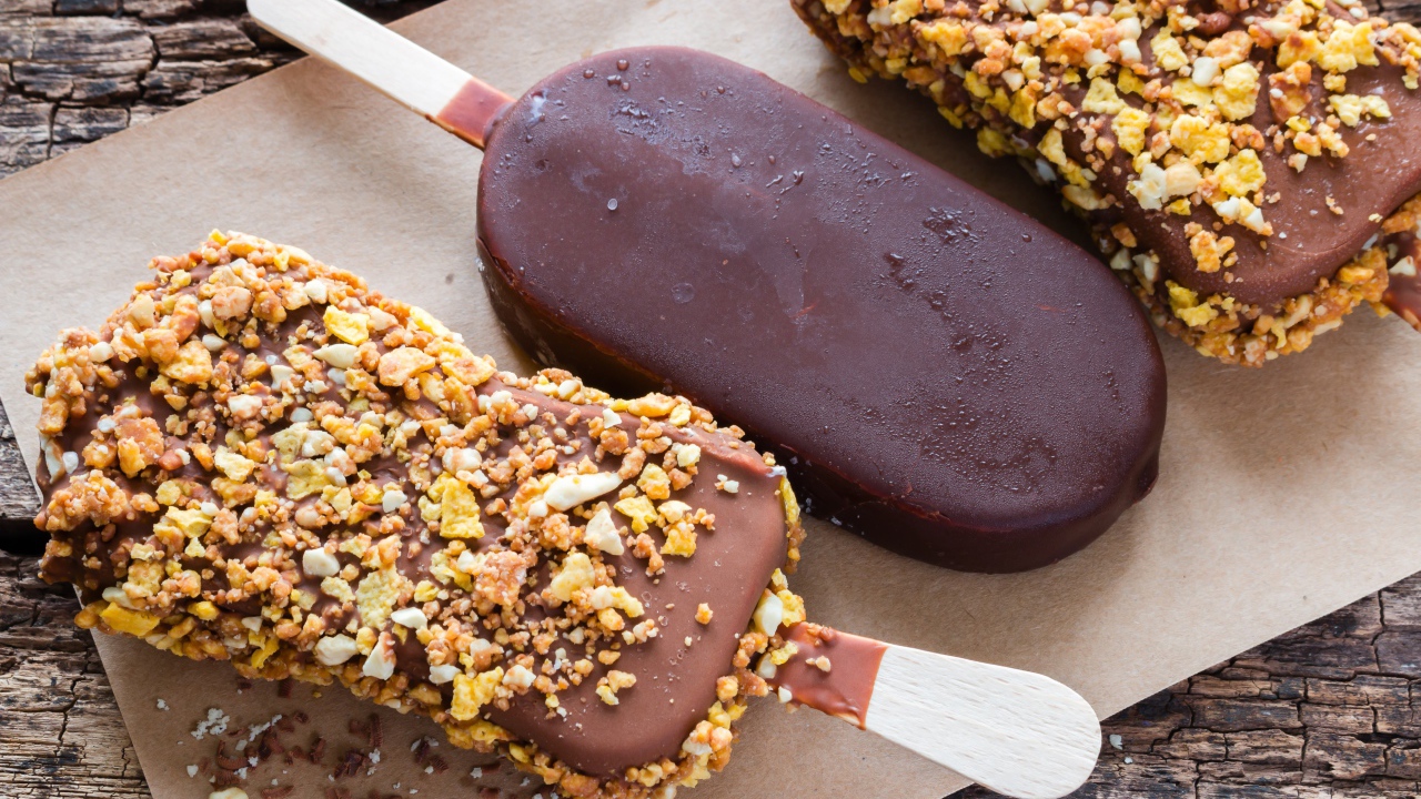 Вкусное холодное мороженое в шоколаде на столе 