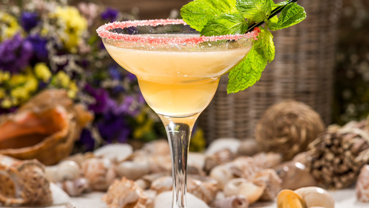 Коктейль с мятой в бокале на столе с ракушками 