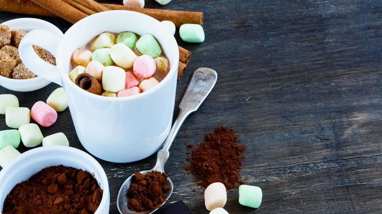 Кофе с маршмеллоу на столе с корицей и сахаром