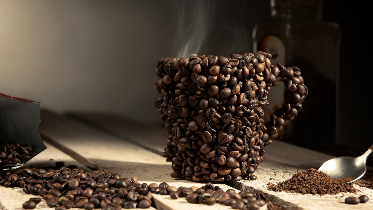 Чашка сделана из кофейных зерен на столе