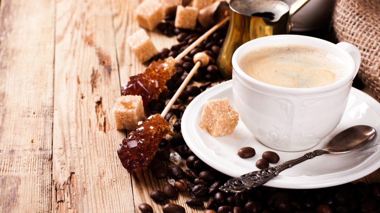 Чашка кофе на столе с леденцами и зернами