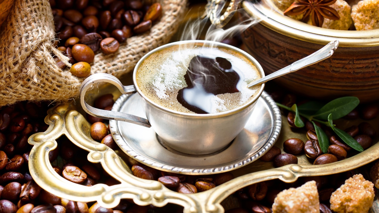 Чашка горячего вкусного кофе на столе с зернами