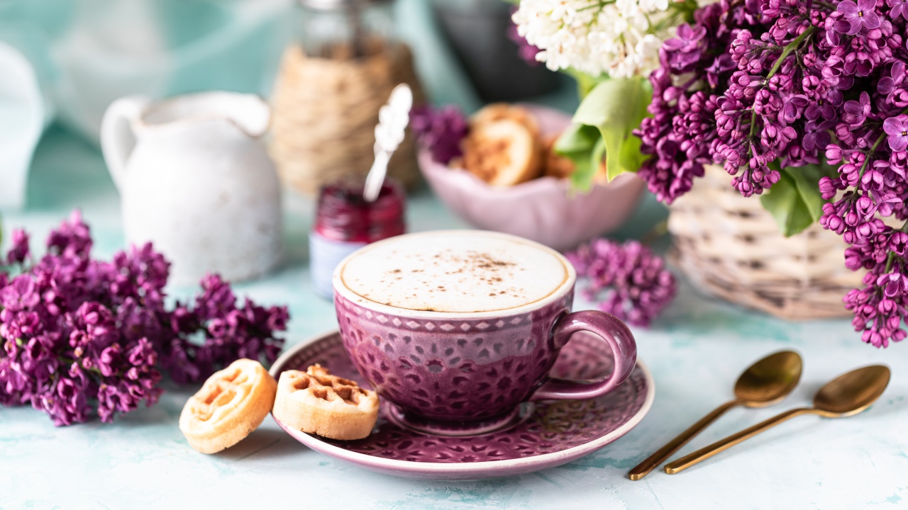 Чашка вкусного кофе с печеньем на столе с букетом сирени