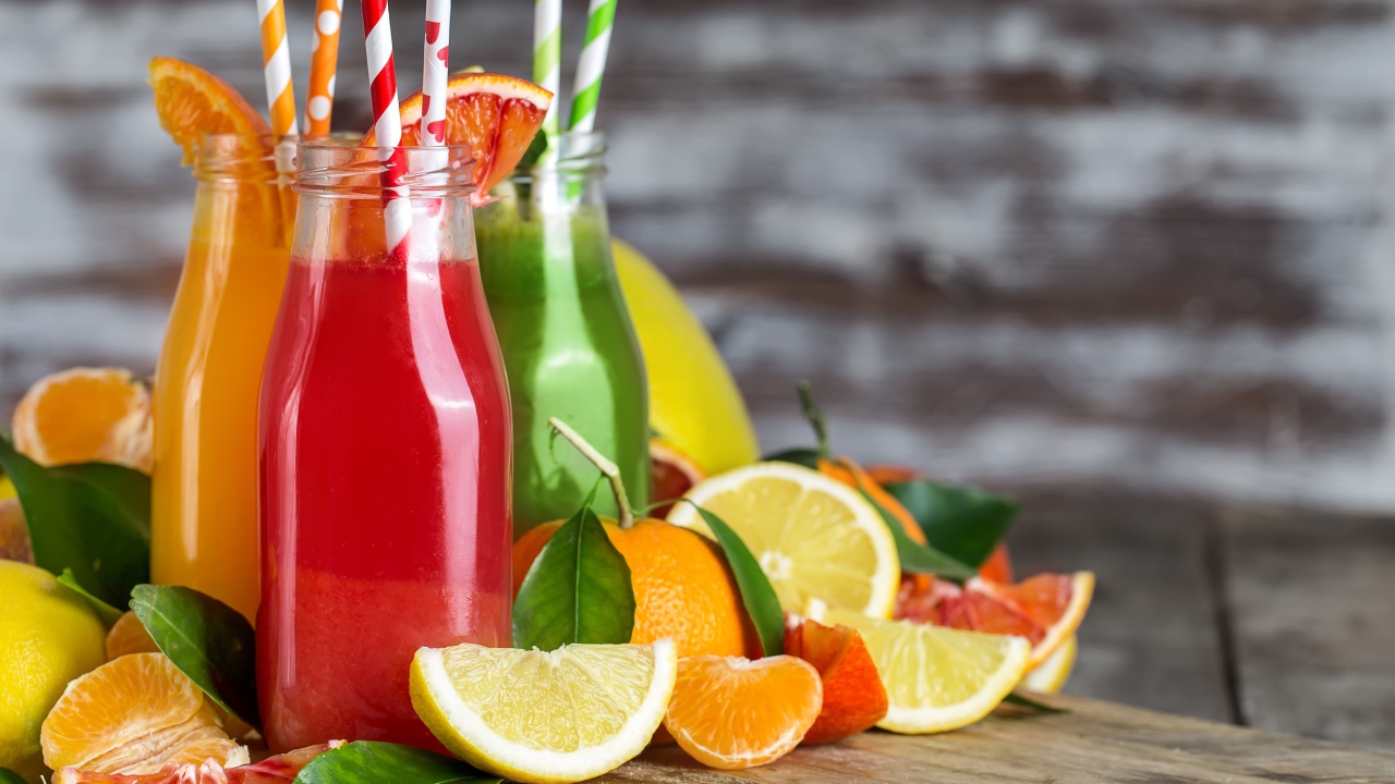 Фруктовое смузи на столе в бутылках с трубочками