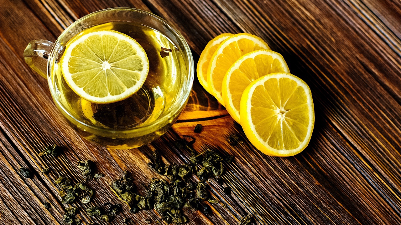 Зеленый чай в стеклянной чашке с лимоном