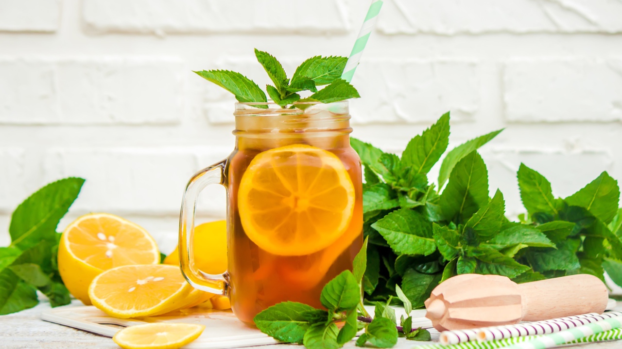 Лимонад на столе с лимоном и листьями мяты 