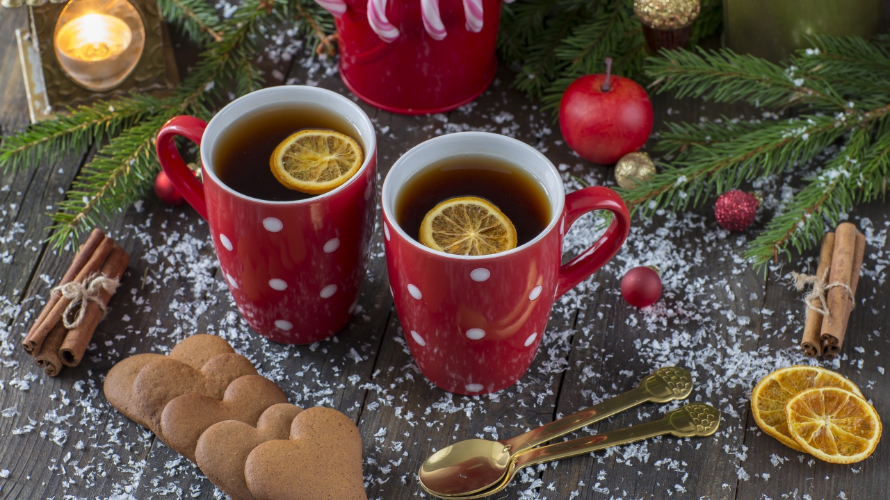 Две чашки чая с лимоном на столе с печеньем и еловыми ветками