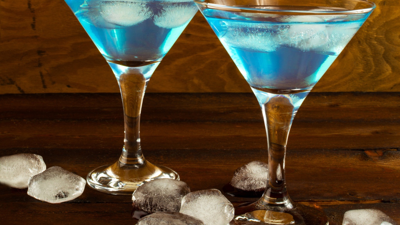 Два бокала коктейля на столе с кусочками льда