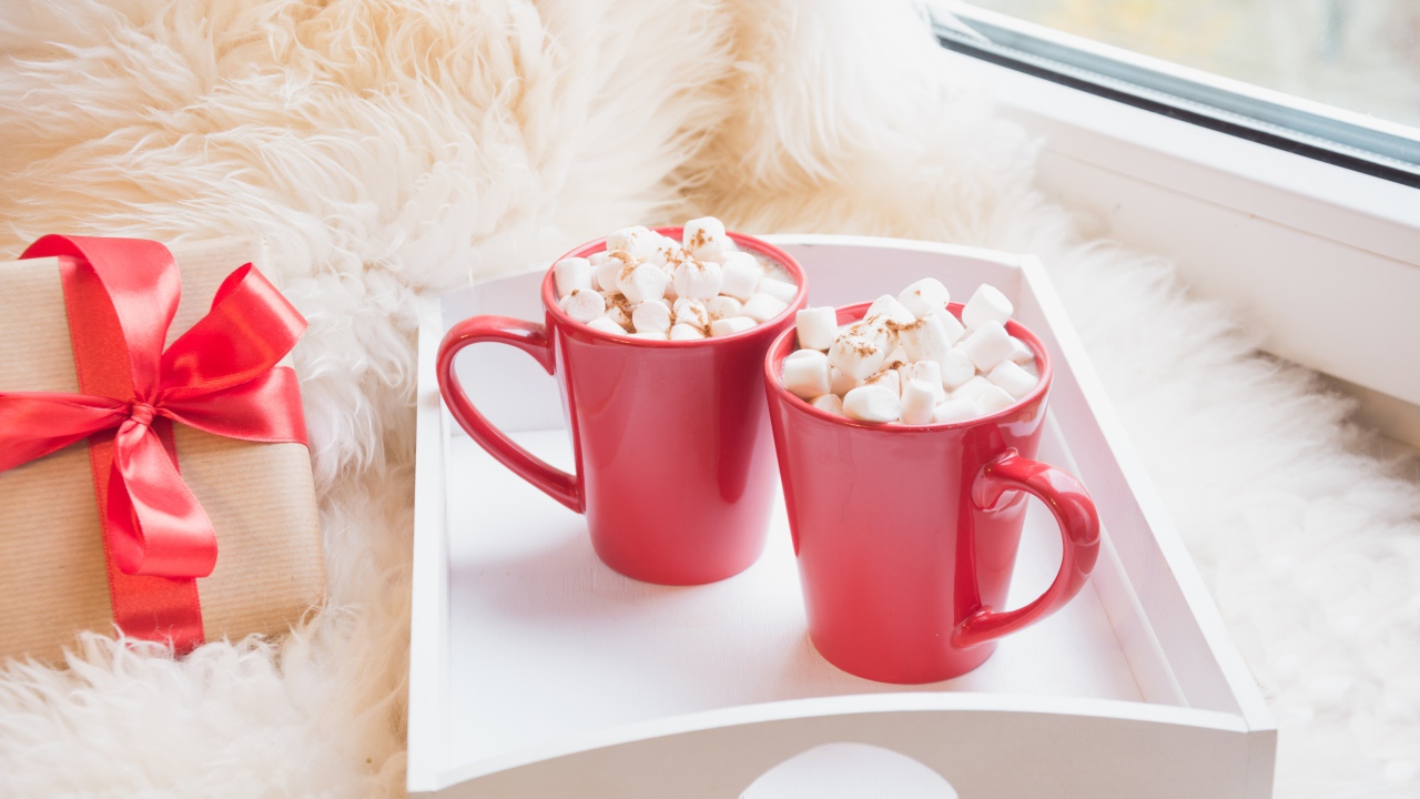 Две красные чашки с маршмеллоу у окна