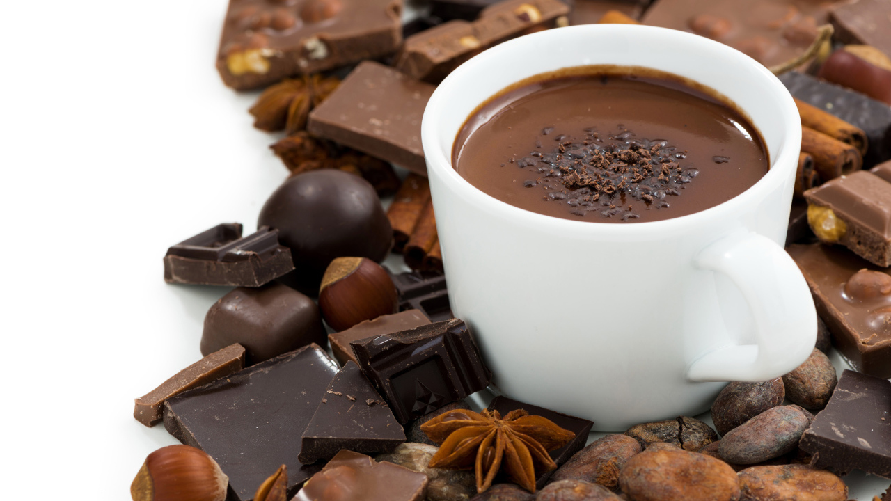Белая чашка горячего шоколада на столе с шоколадом