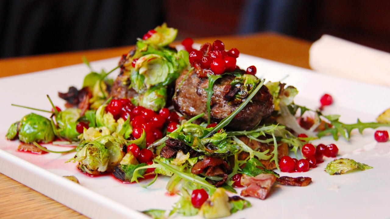 Кусок жареного мяса с салатом на тарелке