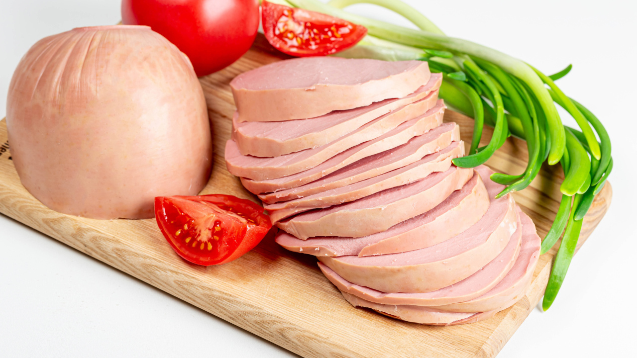 Вареная колбаса на доске с луком и помидором