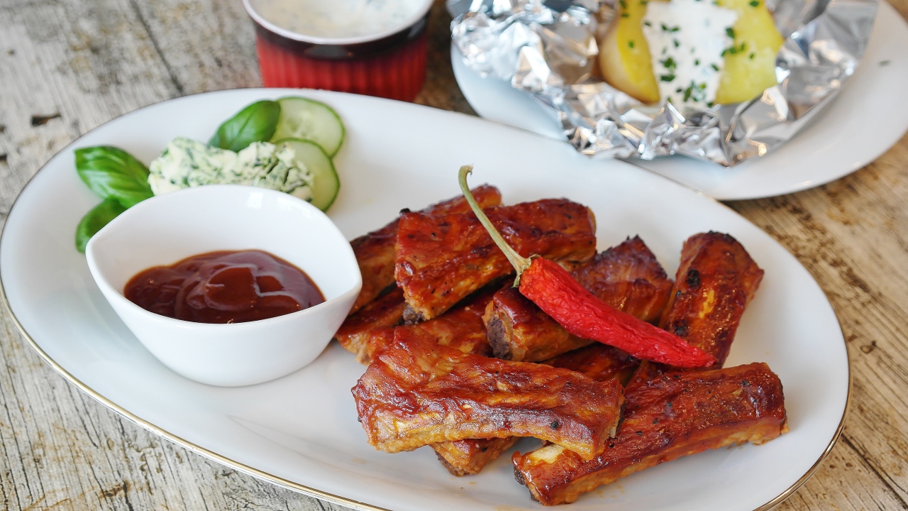 Ribs on a plate with sauce and hot pepper