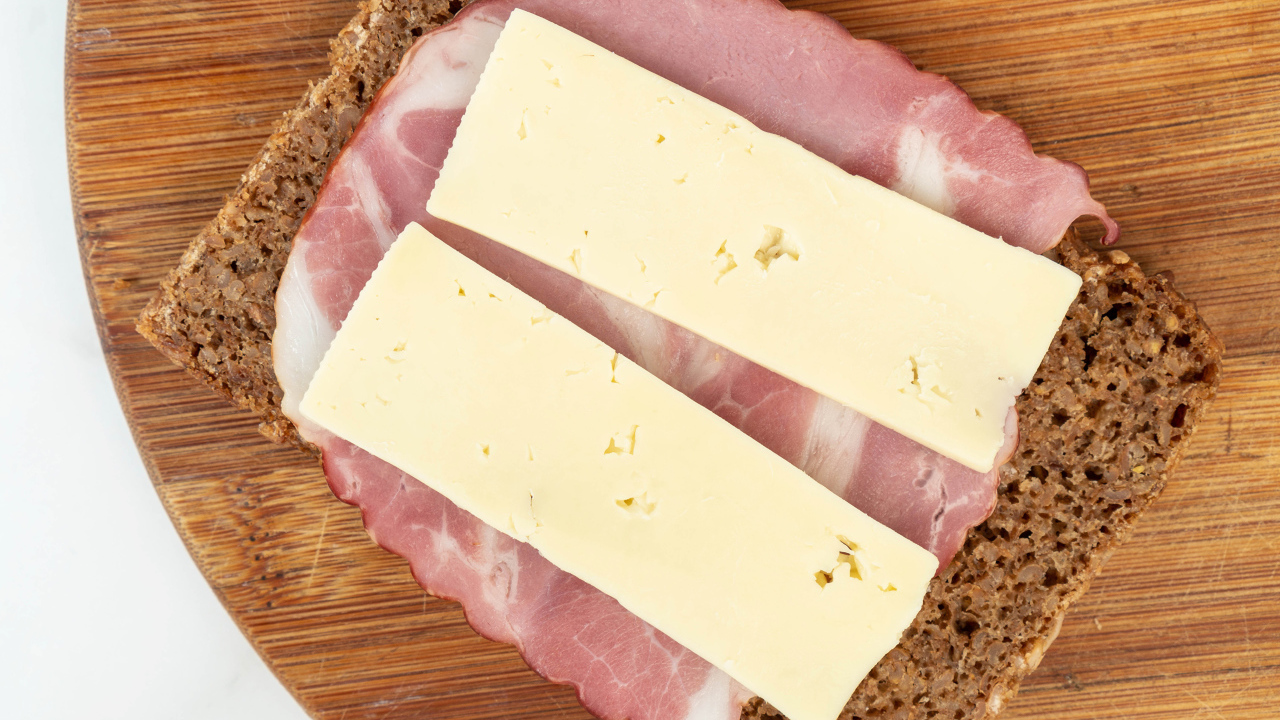 Бутерброд с ветчиной и сыром на доске 