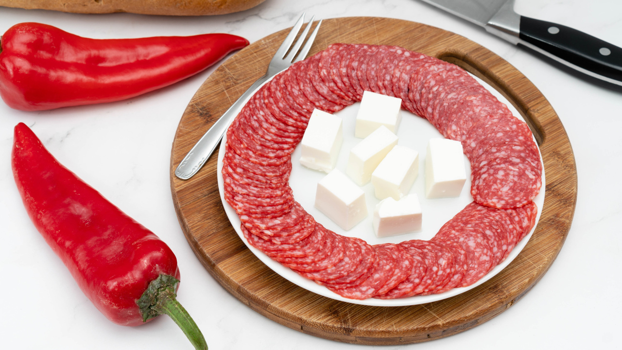 Колбаса с сыром на столе с красным сладким перцем