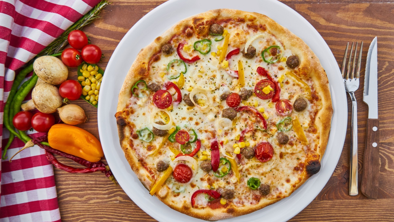 Аппетитная вкусная пицца на столе с овощами 