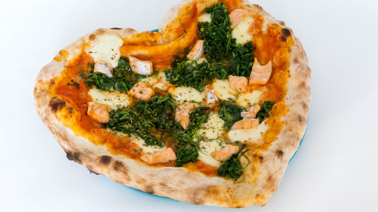 Heart shaped pizza with fish and cheese on a white background