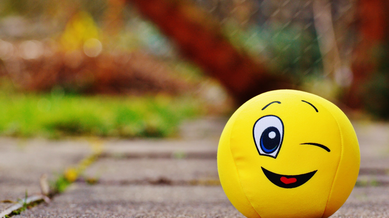 Yellow ball emoticon winks eye