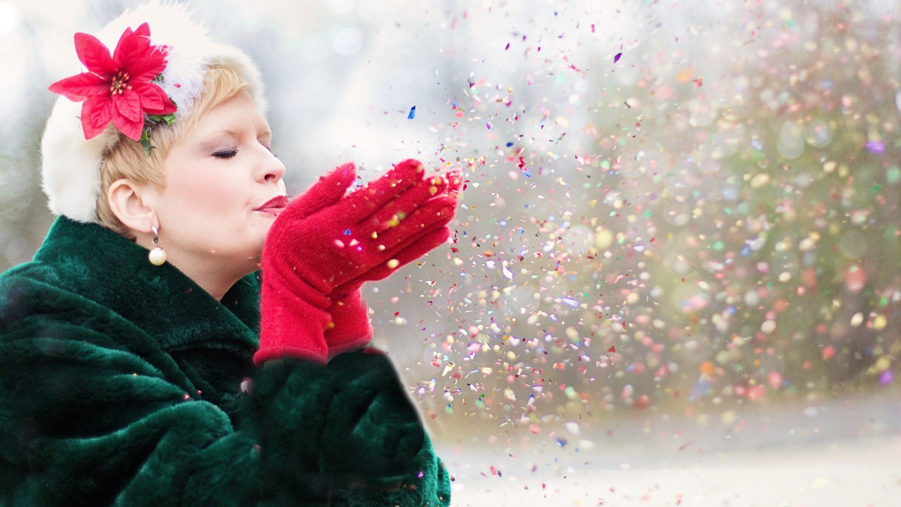 Женщина в шубе сдувает конфетти с ладоней