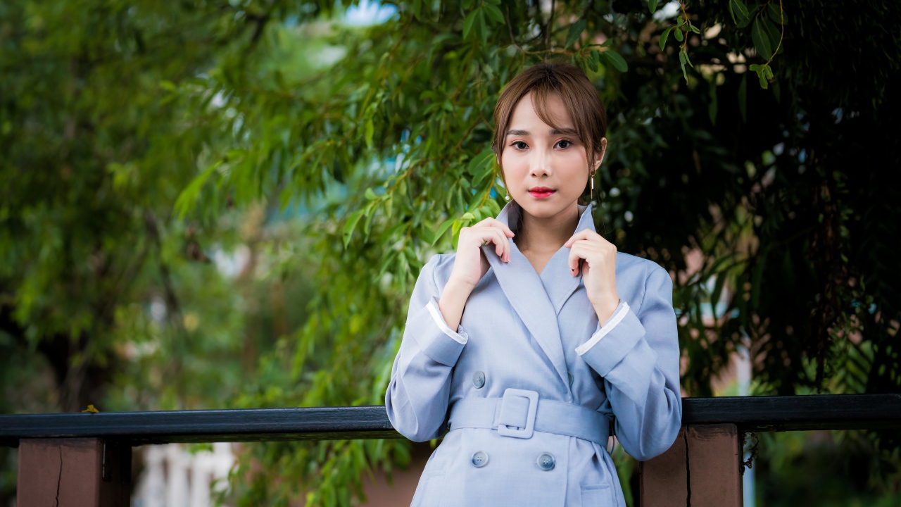 Девушка азиатка в голубом пальто в парке