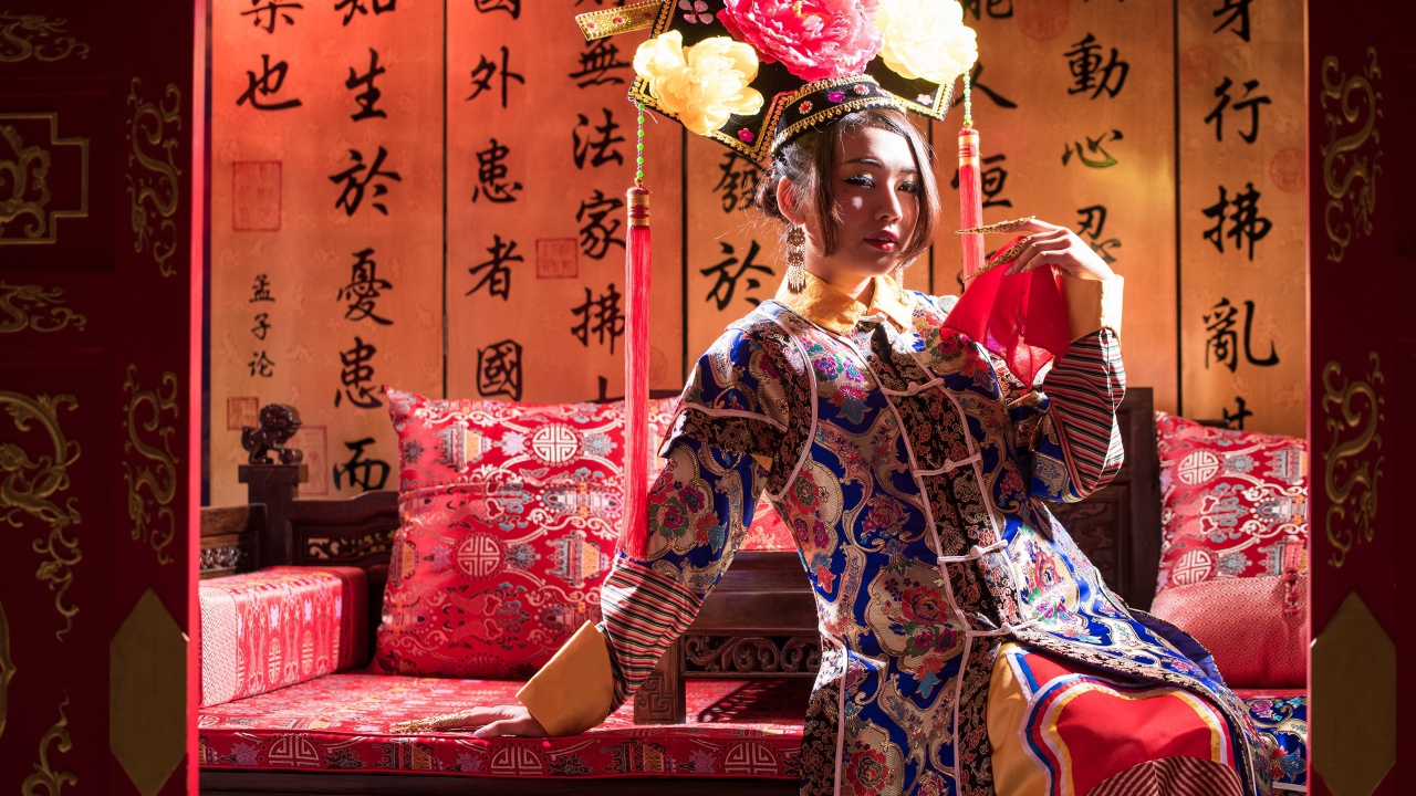 Красивая девушка азиатка в национальном костюме на диване