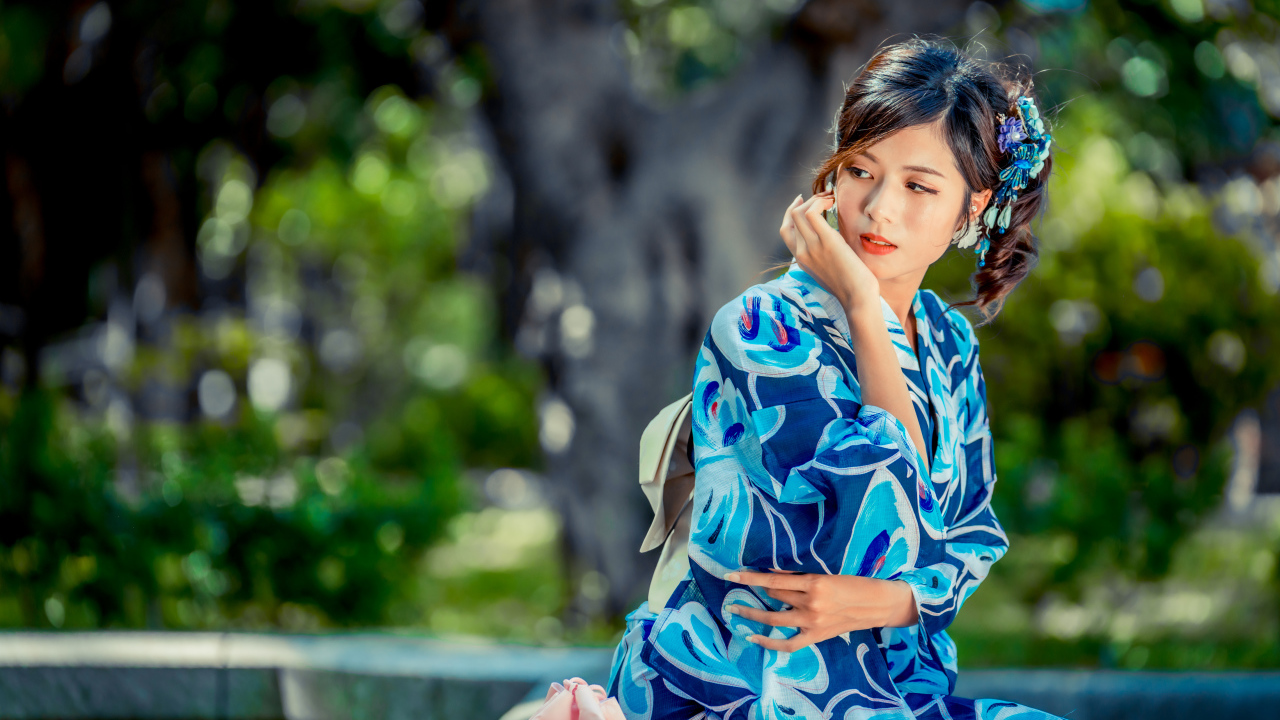 Красивая азиатка в разноцветном кимоно в парке