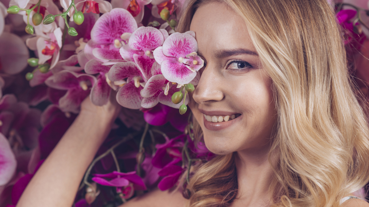 Красивая девушка блондинка с цветами орхидеи