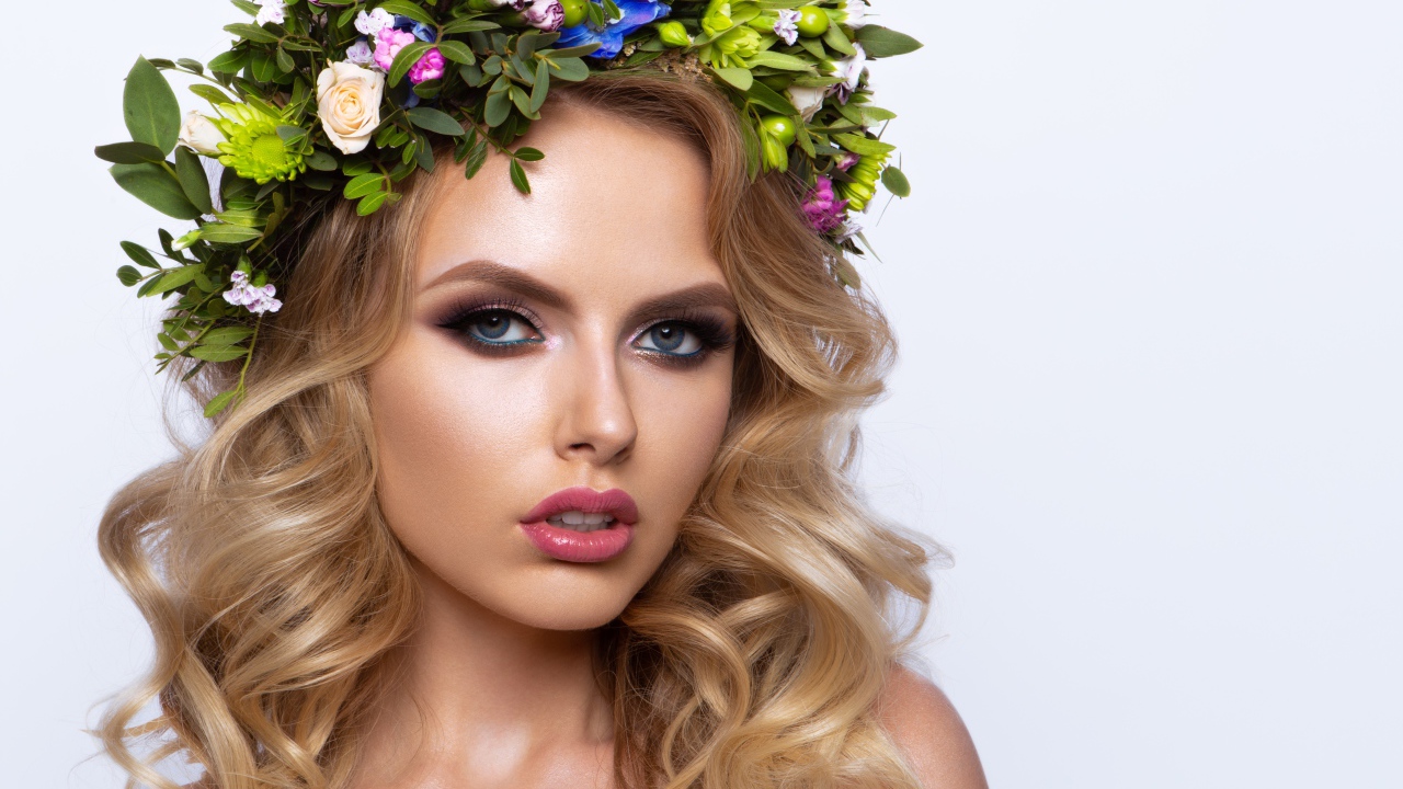 Красивая блондинка с венком из живых цветов на белом фоне