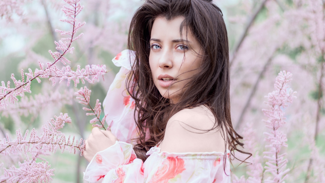 Красивая голубоглазая девушка в розовых зарослях 