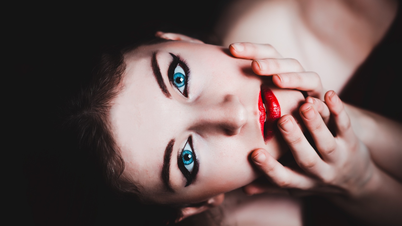 Красивая голубоглазая девушка с красными губами смотрит вверх 