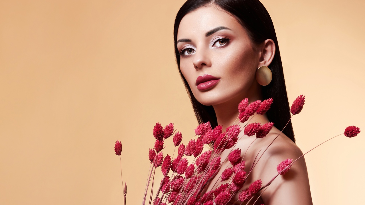 Красивая брюнетка в букетом красных цветов 