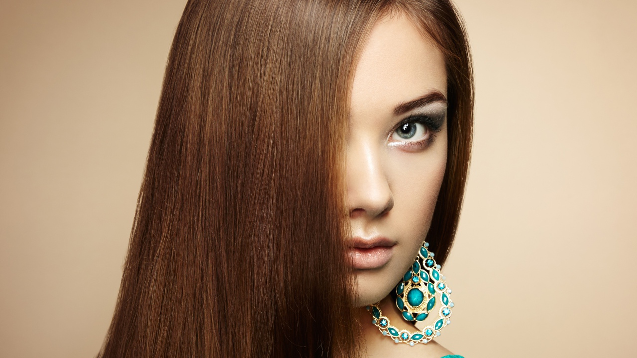 Красивая девушка в голубом платье с сережками в ушах