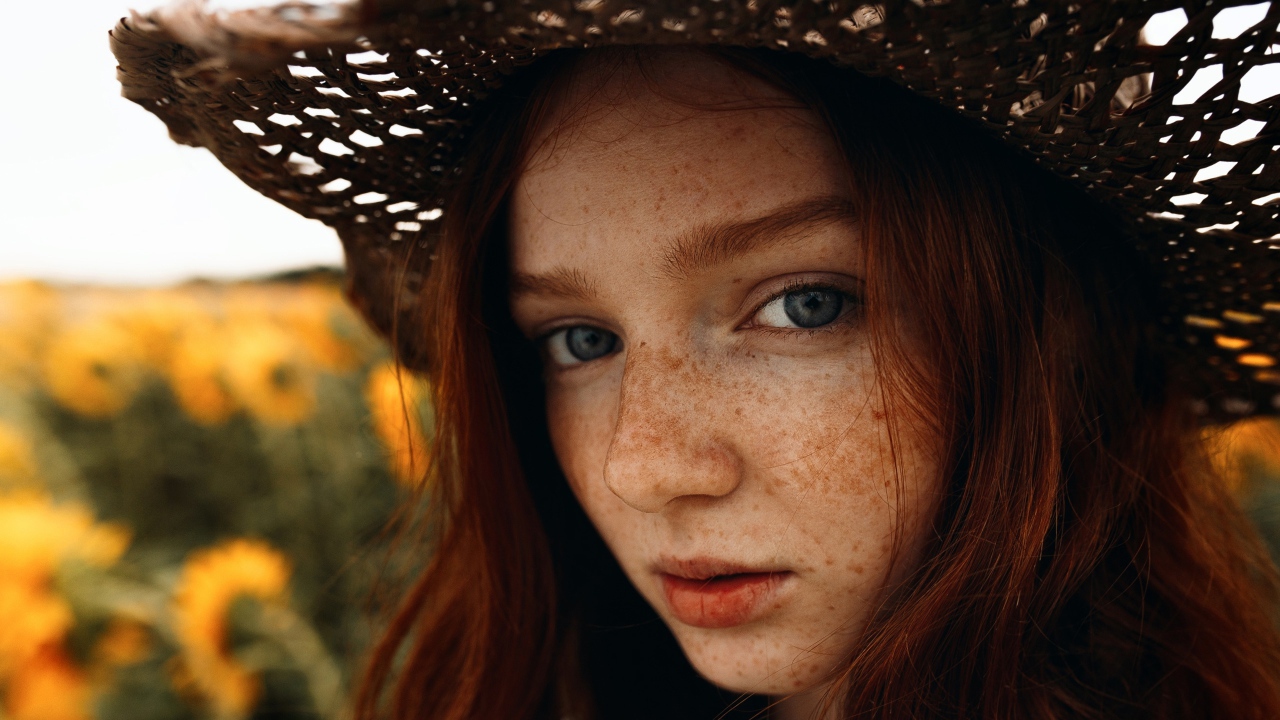 Красивая девушка в шляпе с веснушками на лице 