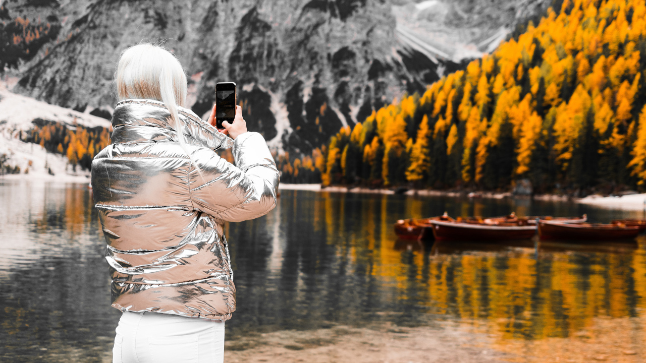 Красивая девушка делает фото гор на телефон 