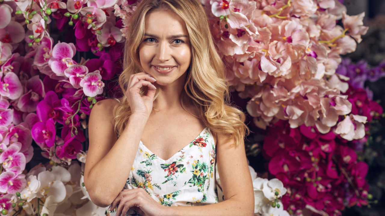 Красивая девушка на фоне цветов орхидеи