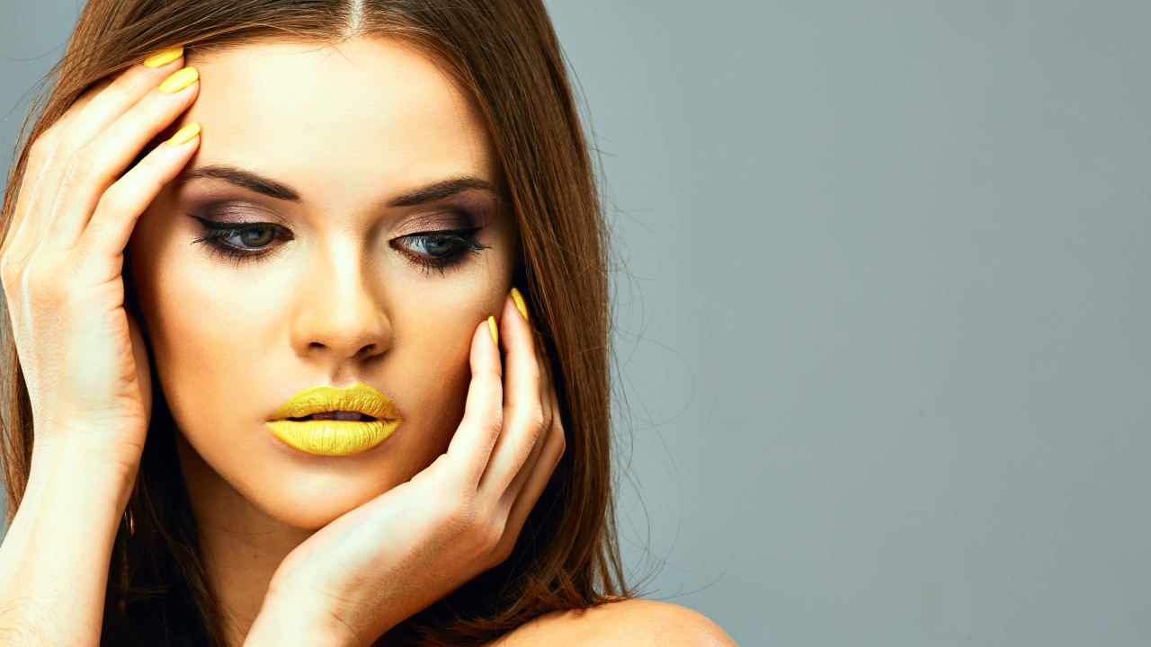 Красивая девушка с желтыми губами на сером фоне