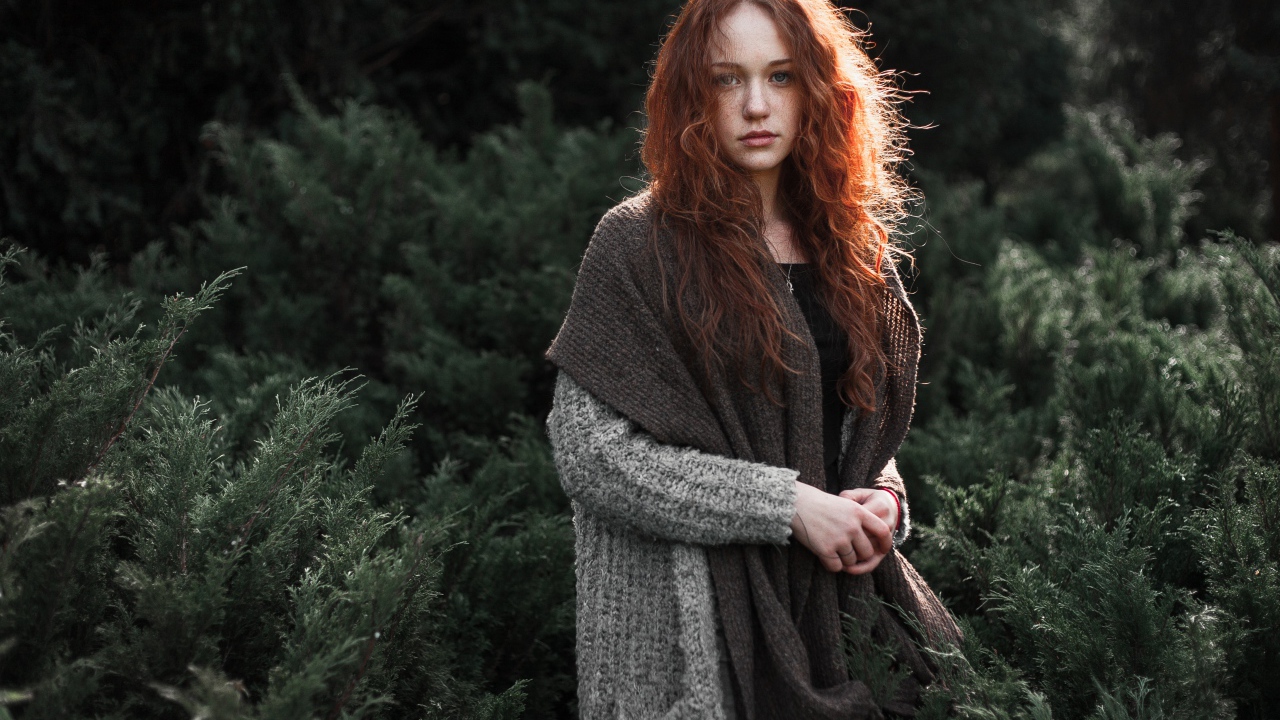 Красивая рыжеволосая девушка в серой кофте 