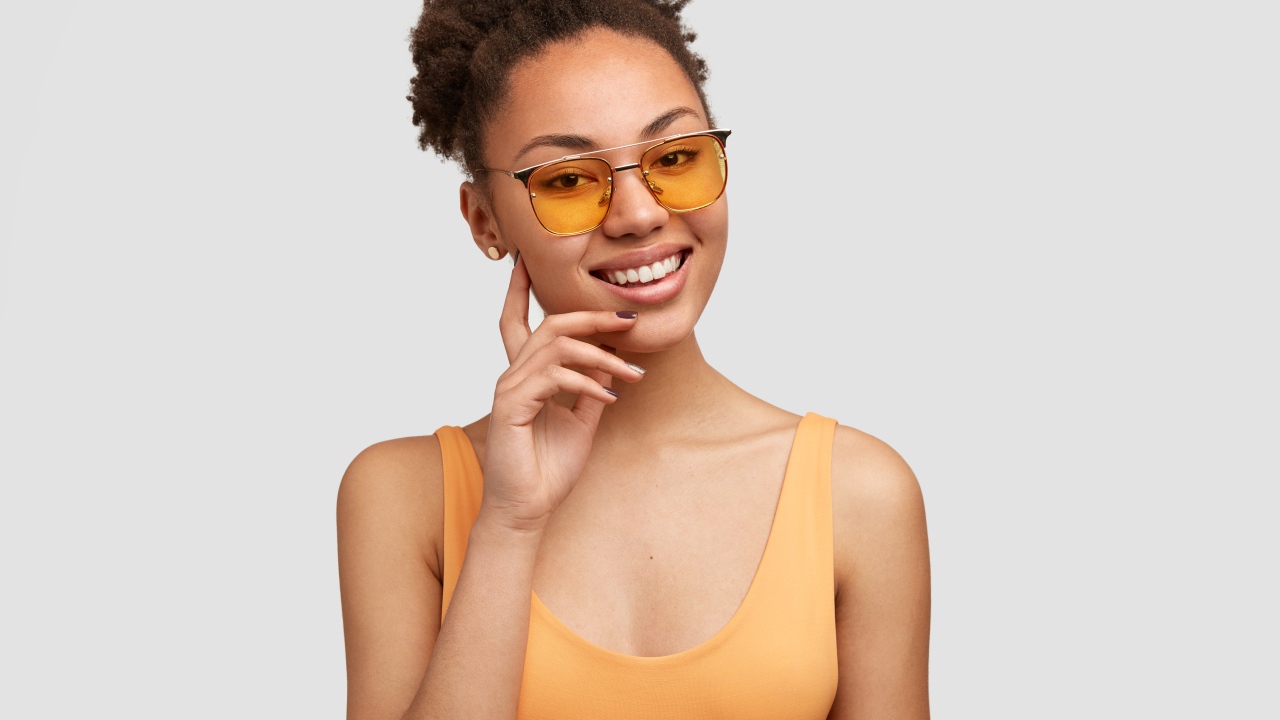 Красивая улыбающаяся темнокожая девушка в солнечных очках