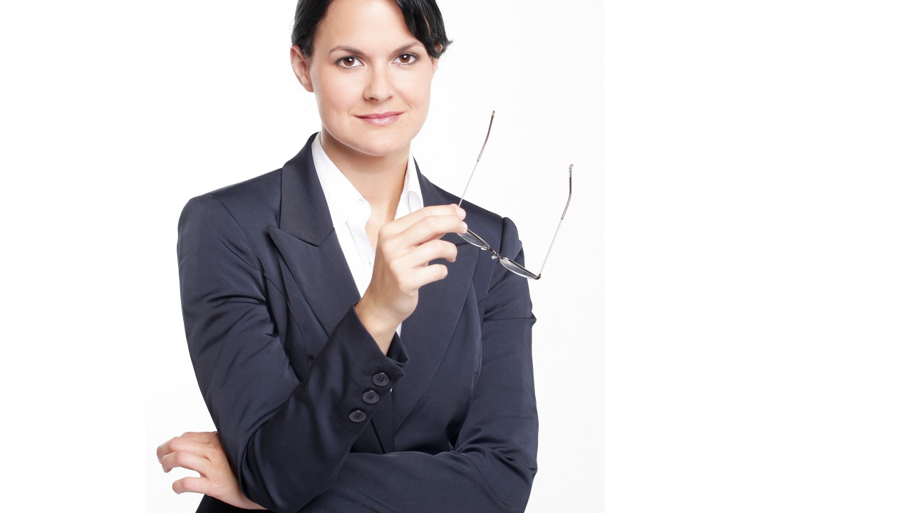 Деловая женщина в костюме с очками в руке