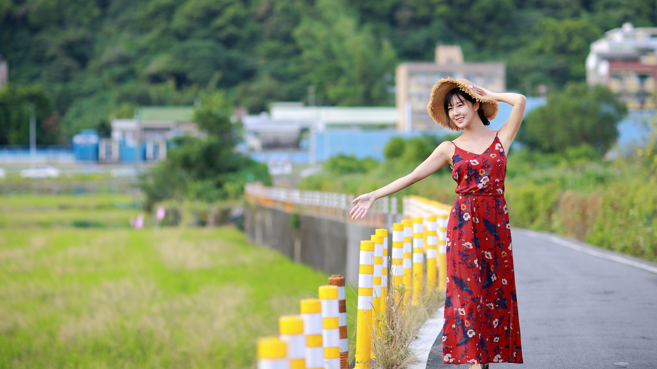 Веселая девушка азиатка в цветастом сарафане 