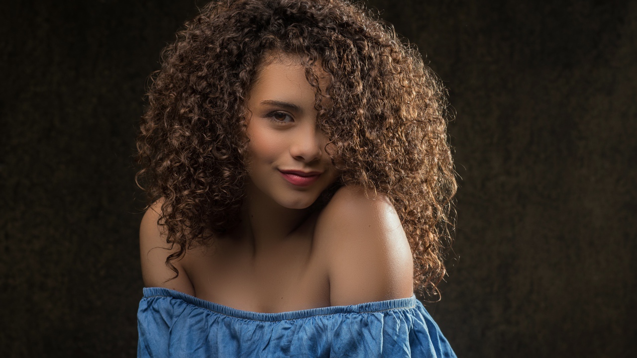 Милая кудрявая девушка в платье