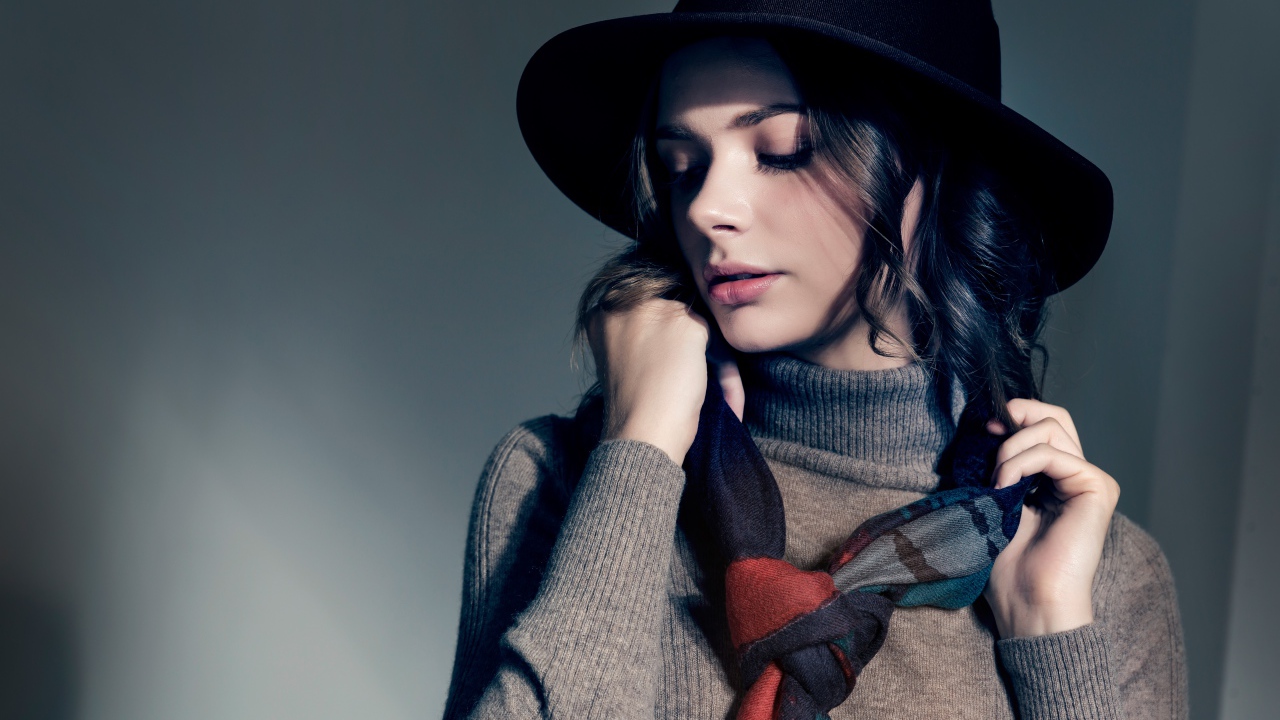Девушка в сером свитере с платком на шее в черной шляпе